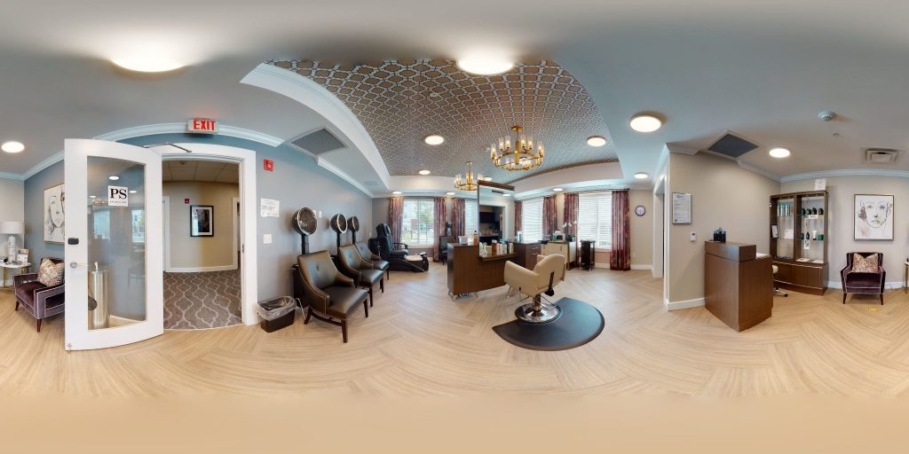 Elegantly designed salon with styling chairs, hair dryers, and large windows.