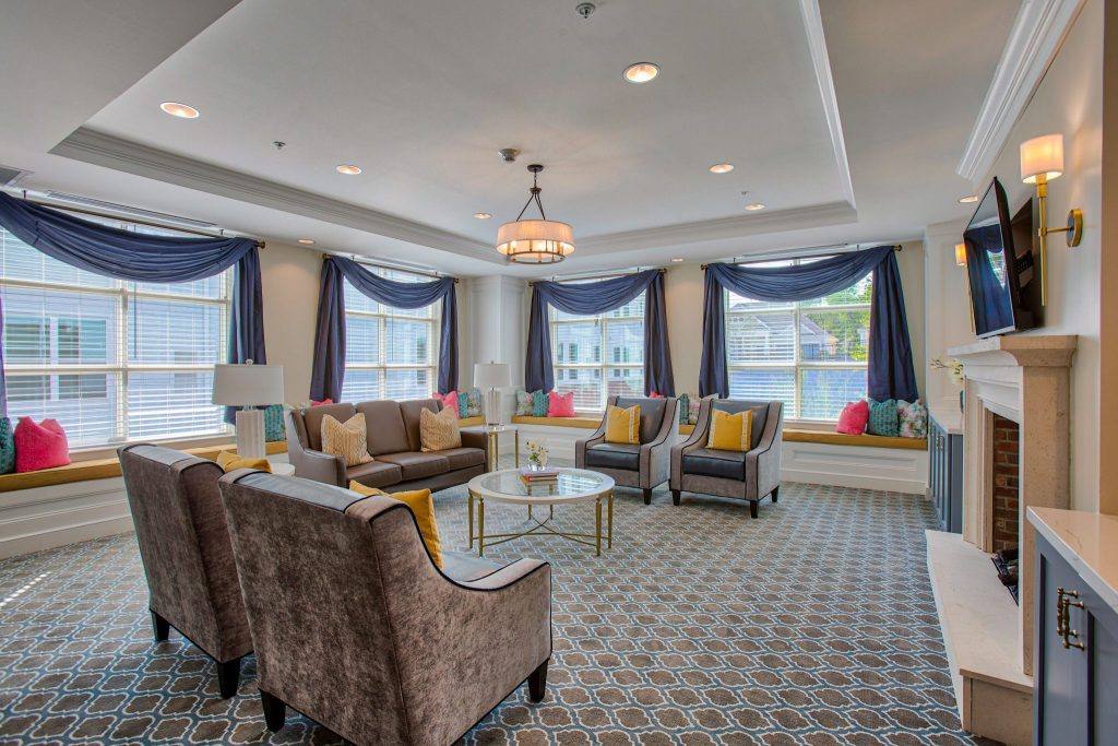 Bright lounge area with large windows, comfortable seating, and a fireplace.