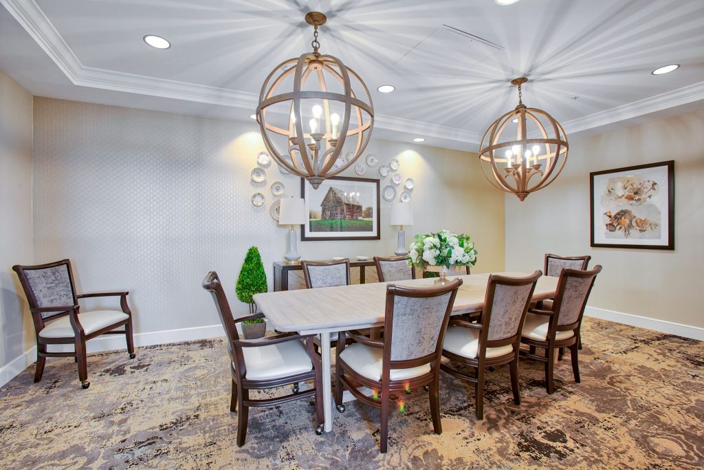 Elegant dining room with a wooden table and modern spherical chandeliers.