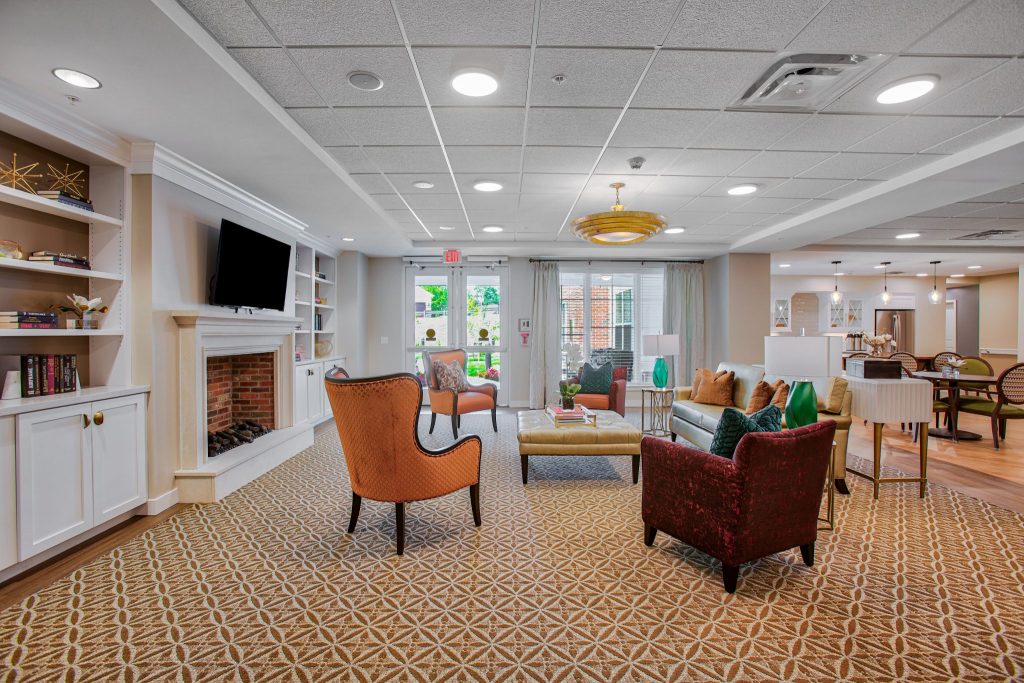Cozy living area with colorful chairs, TV, and fireplace in a communal space.