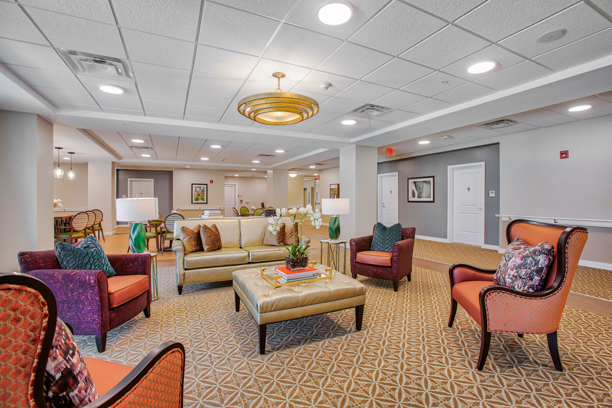 Modern lounge area with patterned carpet and seating at a residential building.