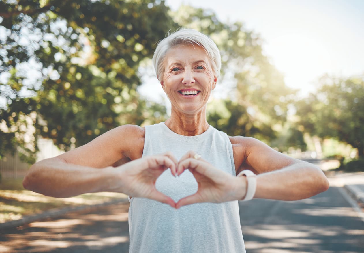 senior woman holding her hands in the shape of a heart