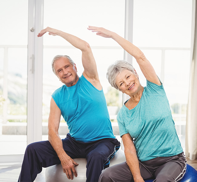 Seniors stretching arms while seated
